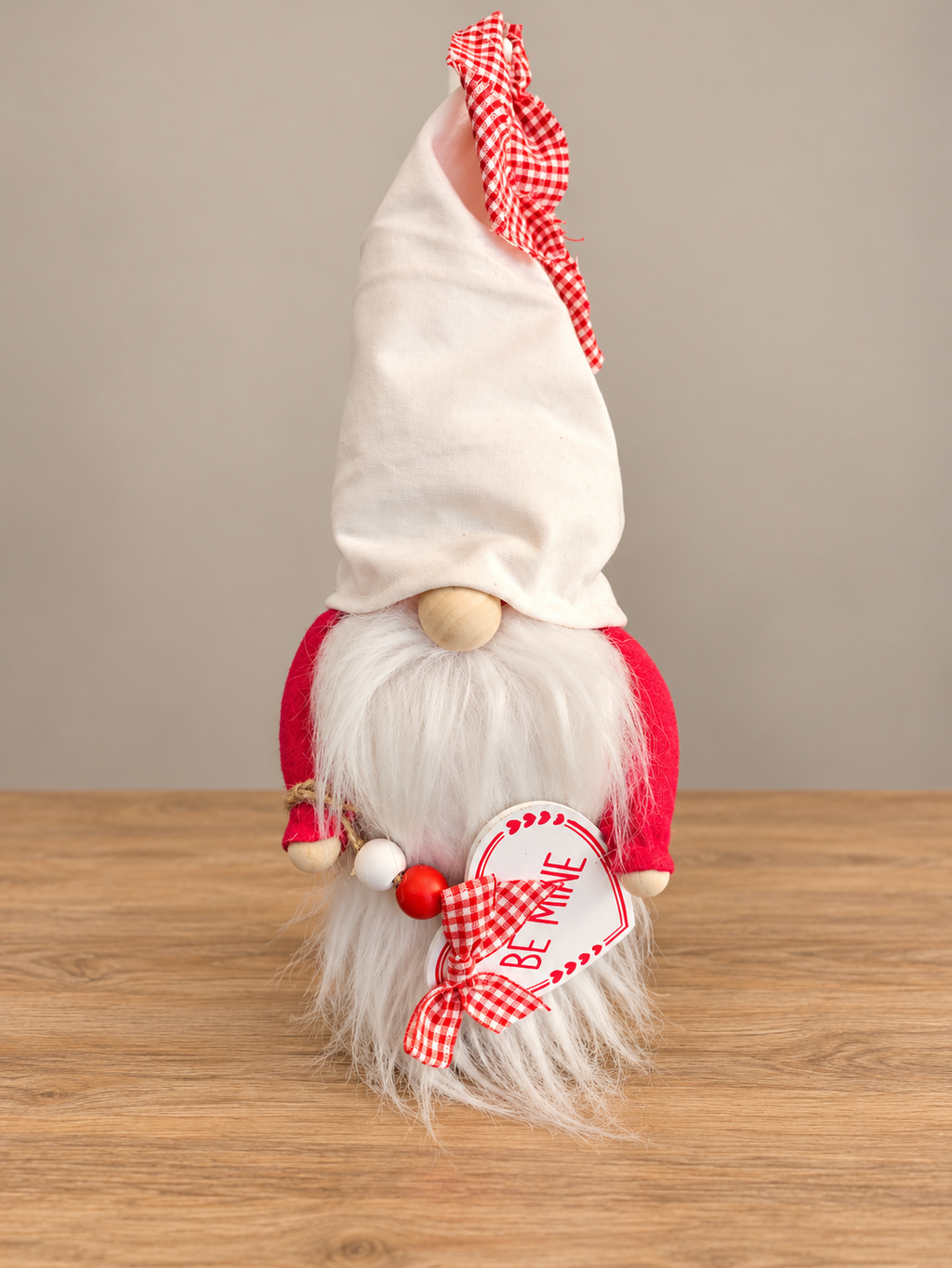 Valentine's Day gnome with white beard, red gingham hat, and Be Mine heart sign